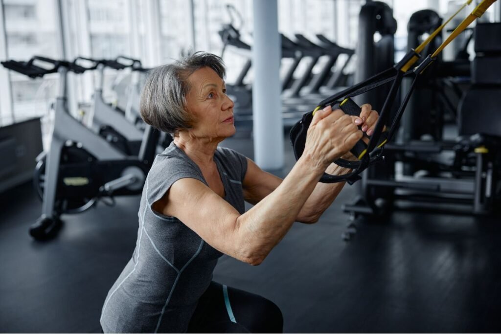 Imagem atual: Mulher madura realizando treinamento de força na academia.